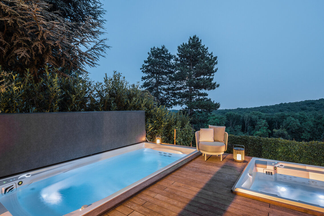 Celoroční bazén USSPA Swim Spa M s mechanickým termokrytem v nočním nasvícení