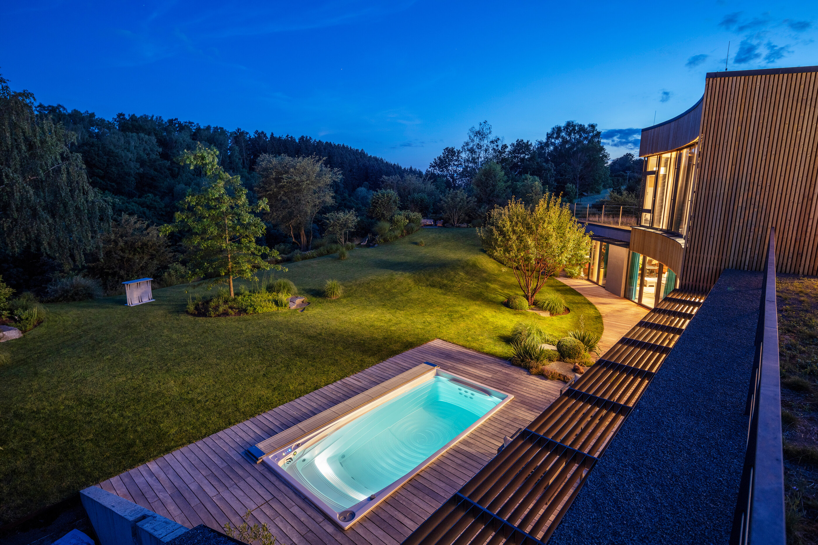 Noční pohled na celoroční bazén USSPA Swim Spa XL s automatickým termokrytem instalován u luxusní vily