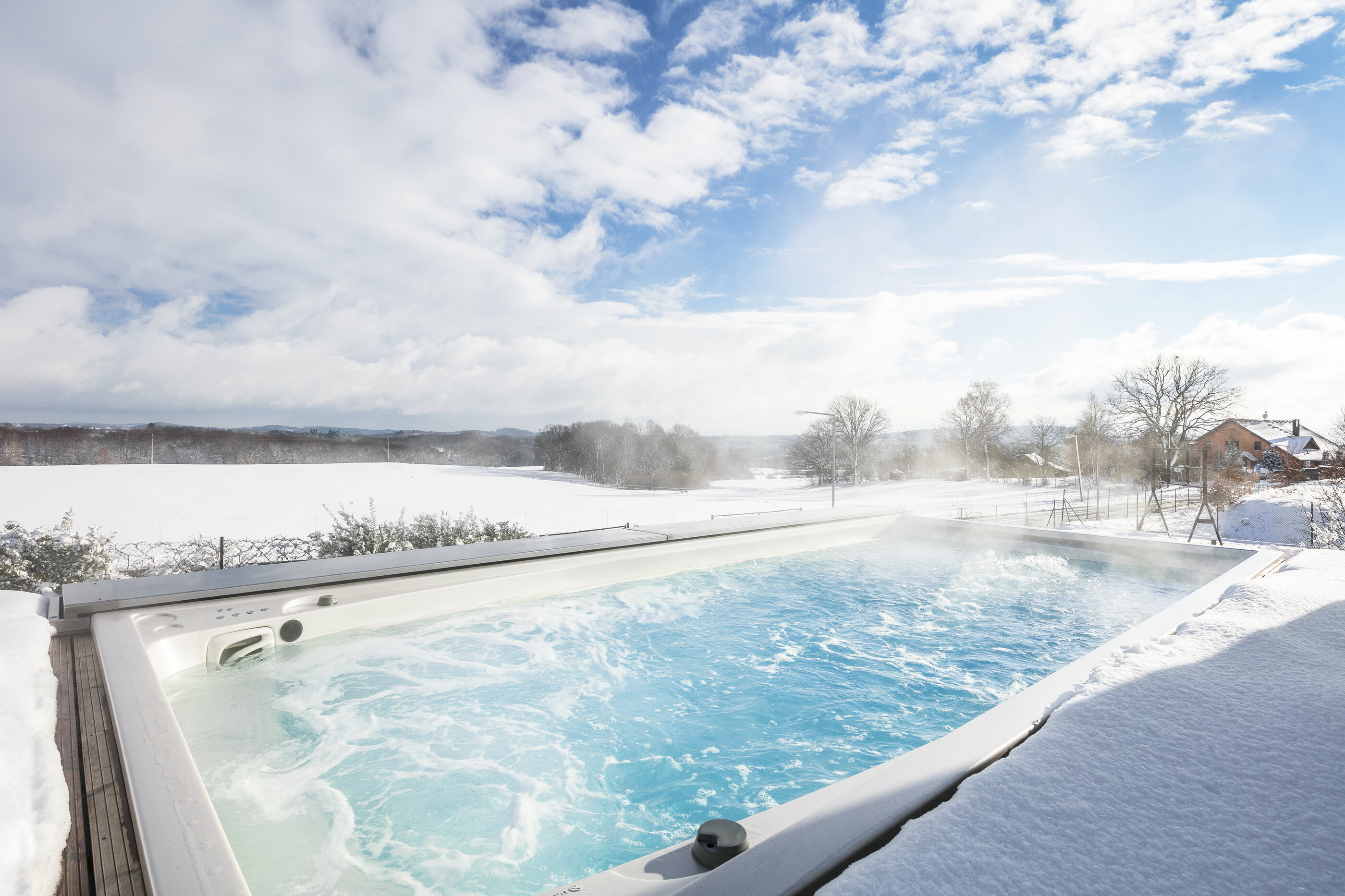 Celoroční bazén USSPA Swim Spa XL s automatickým zakrytím uprostřed zasněžené krajiny